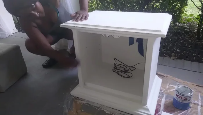 Distress the furniture piece by scuffing it with 120 grit sandpaper, focusing on edges and corners.