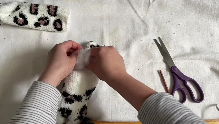 Stuff the body. Turn the sock inside out and fill the body with cotton.