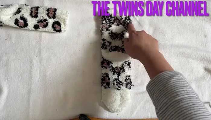 Shape the legs. Curl the sock's toe area to form the cat's feet. Do this for both sides of the sock.