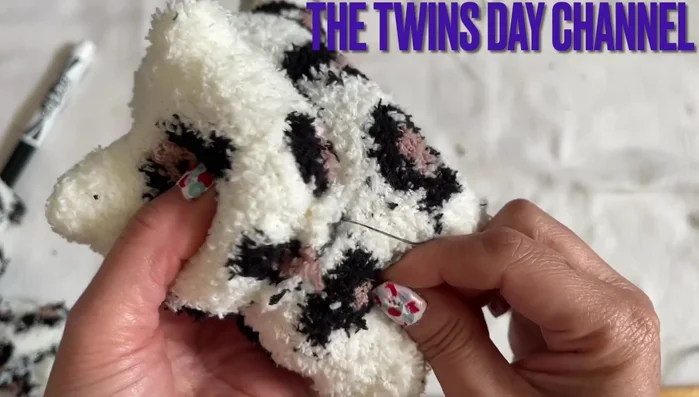 Attach the head to the body. Sew the head to the front of the body, between the legs.