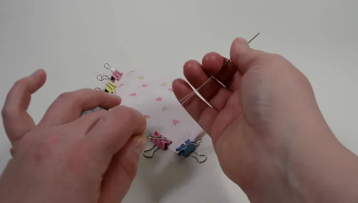 Pass the sewing thread through the yarn darner's hole. Use double thread (equal length on both sides). Create a circle around the bandana, adding about 11 inches, and cut.