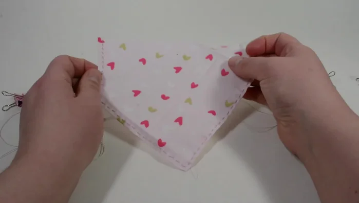 Flatten out the threaded sides. When all folded sides have been threaded, fold in from the top to the middle corners. Use binder clips on the sides and top to hold in place.