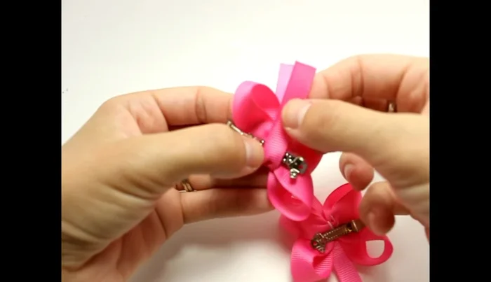 Secure the bow with ribbon: Cut a piece of 3/8 inch ribbon, seal the edges with a lighter, and glue it over the base of the bow on the clip to further secure.