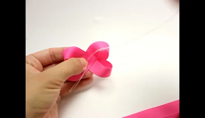 Secure the bow: Use needle and thread to sew through the bow, wrapping the thread around and securing it in the back.