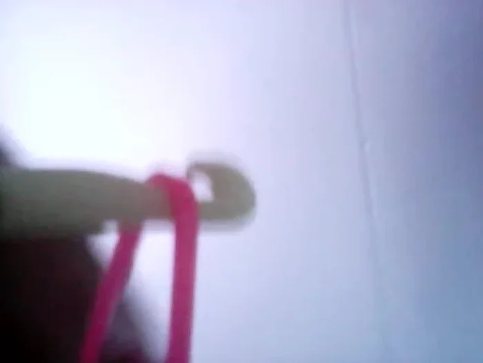 Grab the base ring (pink) with the hook and pull it over the first loop.