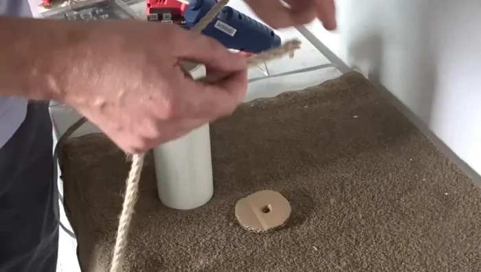 Apply hot glue to the perimeter of the PVC pipe and attach the cardboard.