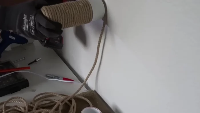 Insert the PVC pipe into the cap. Drill pilot holes into the sides of both and secure with screws. The screws will be hidden by the rope.