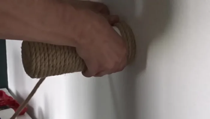 Wrap the rope around the cap, keeping it tight. Cut the edge and use hot glue to secure it to the PVC cap.