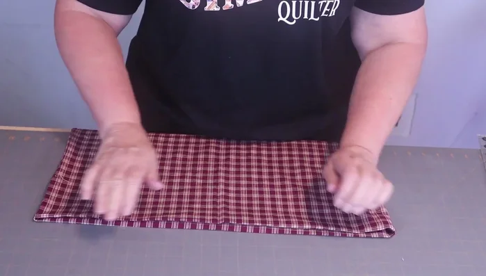 Fold the top edge of the fabric down 1-1.5 inches (no precise measurement needed) and stitch in place.