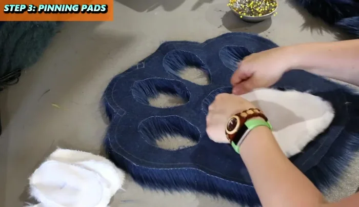 Pin the larger pad to the face of the pillow, tucking in the fur fibers. Pin at key points (top, bottom, sides, corners).