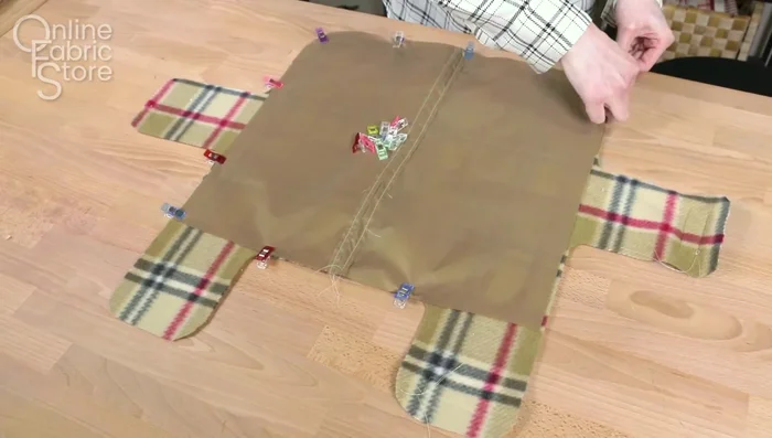 Assemble the coat: Sew the nylon to the fleece. Attach snaps to the fleece and harness flap. Sew the collar to the body, leaving a gap to turn it right-side out. Sew the lining to the body, leaving a gap.