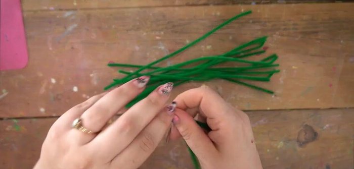 Add more pipe cleaner loops and ribbon weaving to create additional depth and secure the structure. Ensure enough space for flower placement.