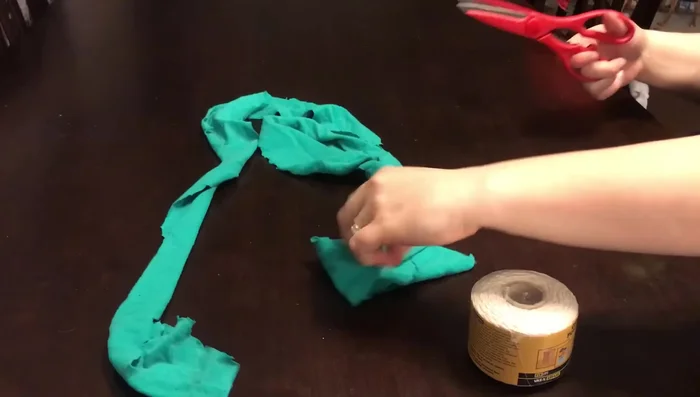 Lay strips of fabric in a cross shape, place ball in the middle, and fold strips over the ball.