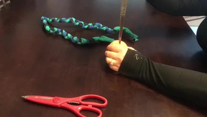 Make two holes in the tennis ball (avoiding the seam).