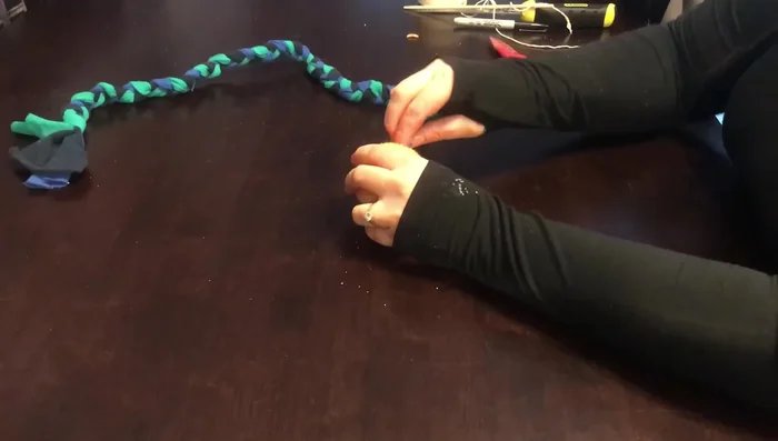 Thread the braided rope through the holes in the tennis ball.