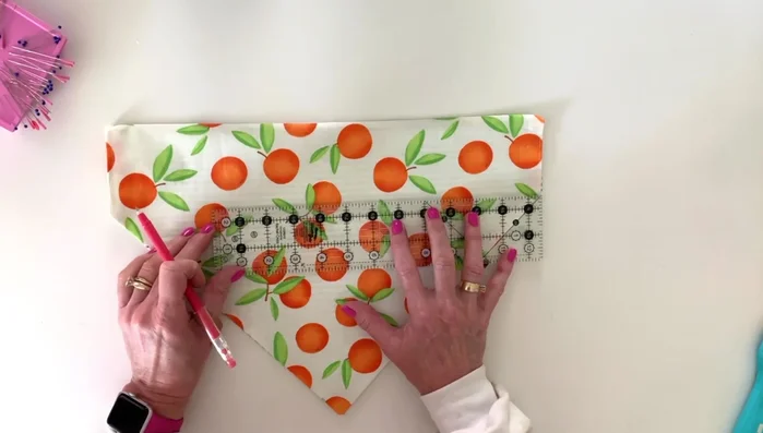 Using a ruler, draw a straight line across the top section. Then topstitch along the drawn line and the outer edges, creating a channel for the collar.