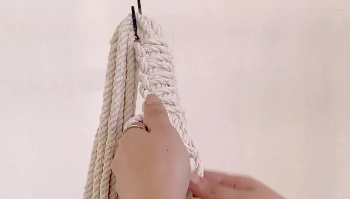 After approximately 8 inches of square knots, find the middle of the cords again and attach them to the S-hook.