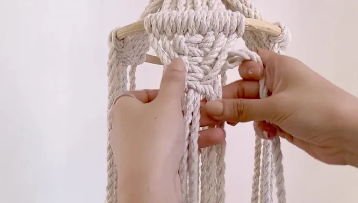 Repeat the square knot pattern until the desired length (18 inches) is achieved, then attach the 12-inch diameter wooden ring using double half-hitch knots.