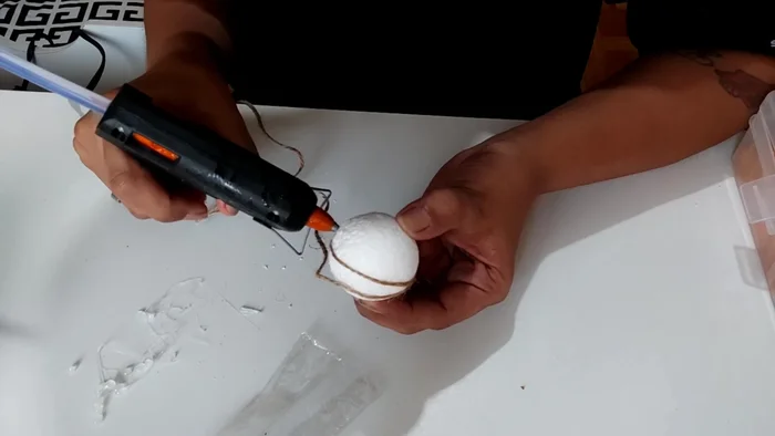 Wrap the twine around the styrofoam ball, covering it completely. Press the twine firmly as you go, since the glue isn't hot enough to melt the styrofoam.