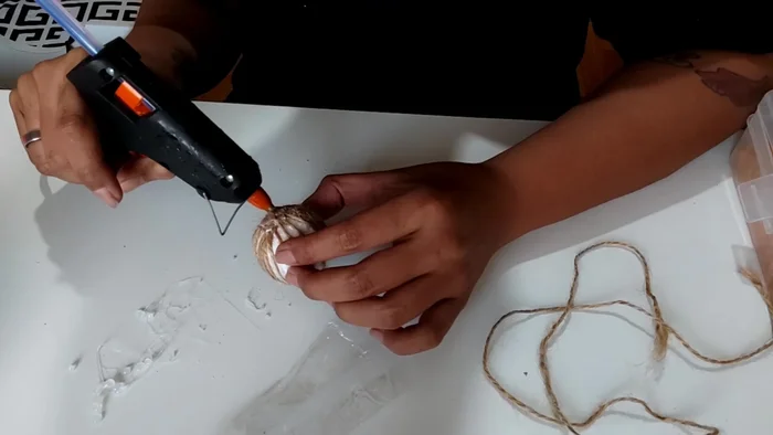 Poke feathers into the glued bottom of the ball, creating a textured surface.