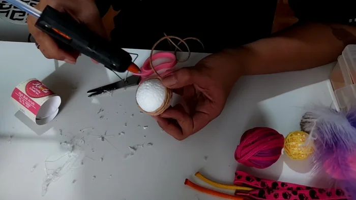 Wrap the stiff paper rope around the styrofoam ball, applying glue liberally.