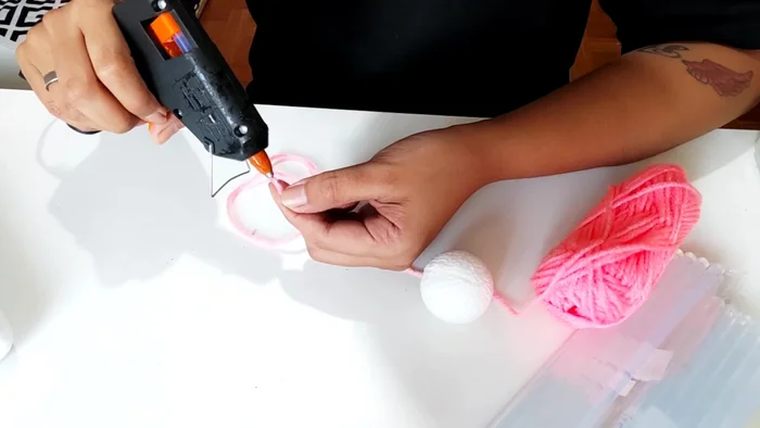 Apply glue to the yarn, not directly to the styrofoam ball to prevent melting.