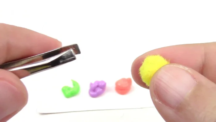 Add fabric paint to pom-poms to create decorative elements for the box.