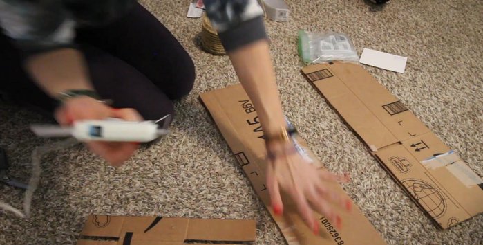 Glue the cardboard pieces together using a hot glue gun. Reinforce the base with packing tape for extra stability.
