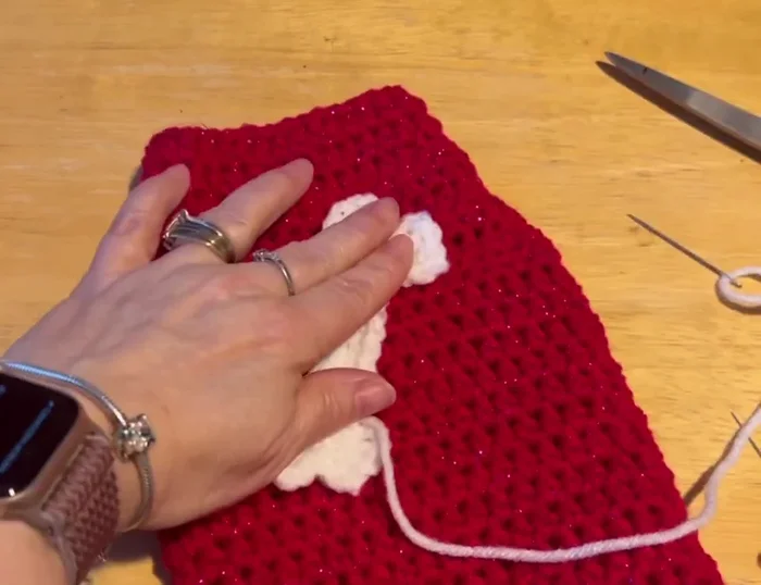 Sew the bone onto the sweater using whip stitch, hiding the ends.