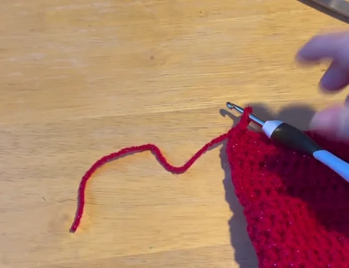 Slip stitch to join the chest to the back of the sweater, pulling the tail tight and tucking it down the center.