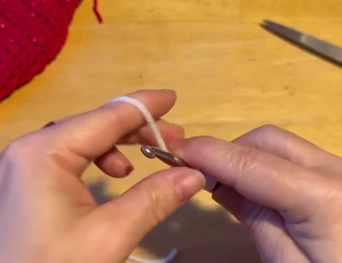 Sew the bone onto the sweater using whip stitch, hiding the ends.