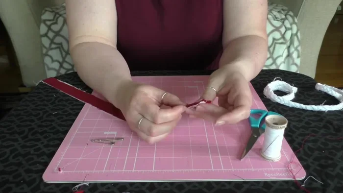 Gather three fabric strips and pin them together about an inch from the top.