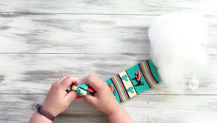 Tie a knot at the toe end of the sock.