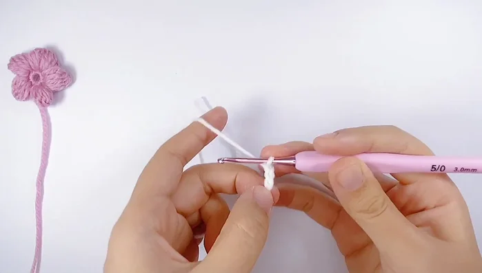 Create the flower center (white yarn): Create a slip knot, chain 3, then work 4 unfinished double crochets in the first chain. Pull through all loops to finish.