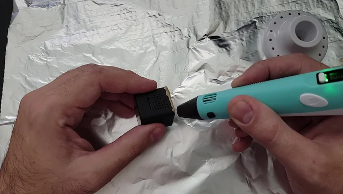 Create the camera cage: Use the 3D doodle pen to draw a cube-shaped frame around the camera's edges. Ensure no buttons or indicator lights are covered. If you make a mistake, let the plastic cool, break it off, and try again.