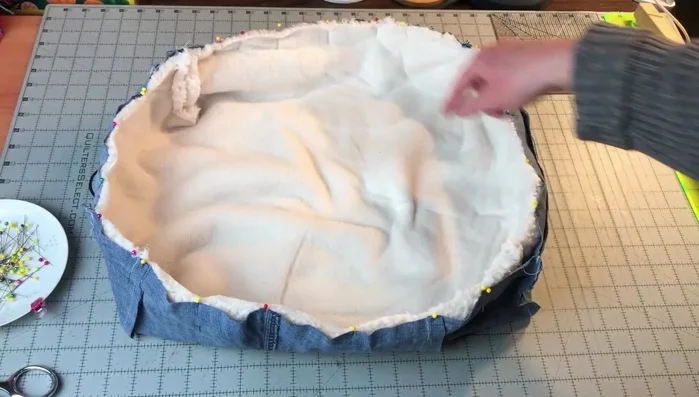 Sew the main pieces together: Place the jeans and sherpa fabrics right sides together, matching corners. Pin all around, leaving two 4in openings on opposite corners. Sew a 1/2in seam allowance.