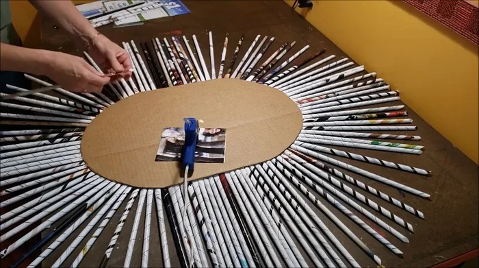Continue weaving additional rows until the desired height is reached. Trim excess vertical tubes, leaving about a half inch above the final row, and cover with additional strips of rolled magazine paper.