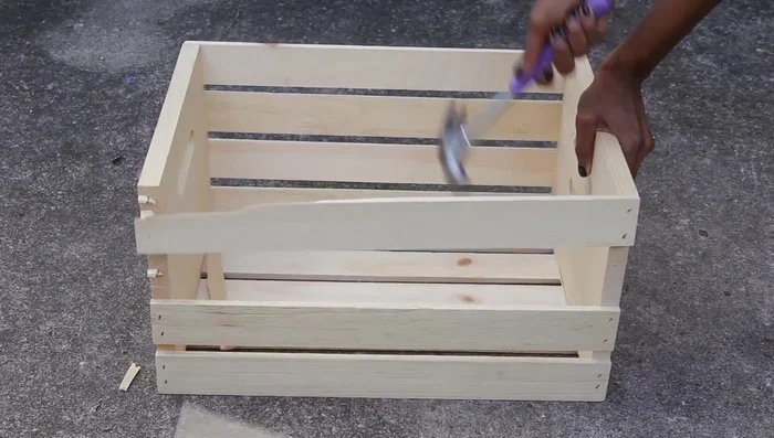 Sand the crate's surface to prep it for painting.