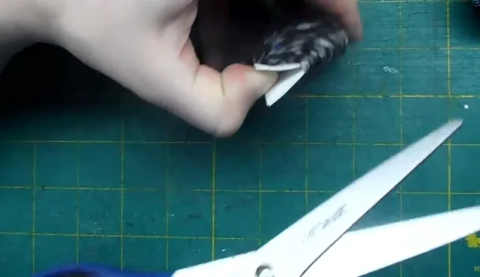 Remove the cardboard. Tighten the initial tie and trim the excess string.