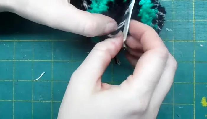 Remove the cardboard. Tighten the initial tie and trim the excess string.