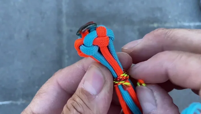 Attach to the ball: Remove the center support. Invert the Turks Head knot and position it atop the ball, aligning with the seam.