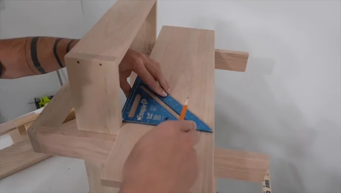 Cut notches in the tabletop boards to fit around the vertical supports, utilizing the first piece as a template for the second.