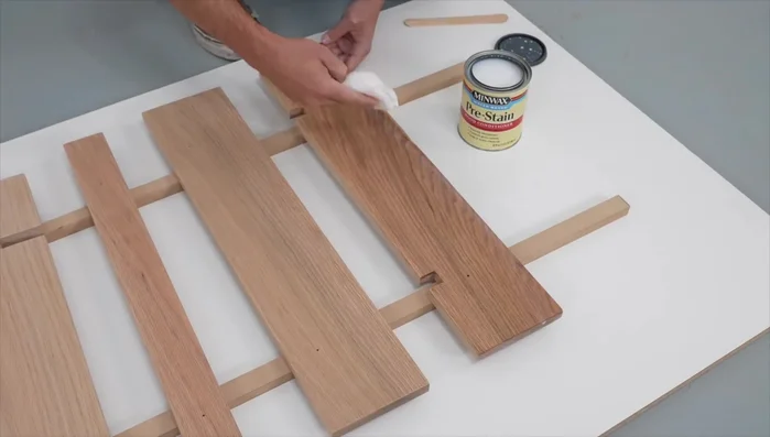 Prepare wood surfaces by removing dust and applying pre-stain wood conditioner. Sand lightly after conditioner dries.