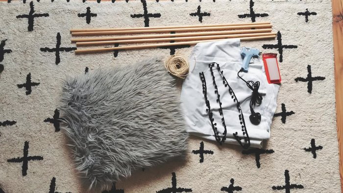 Prepare materials: Gather five wooden dowels, hot glue gun, hot glue sticks, cushions, string, bedsheet, elastic band, and pom-pom fringing.