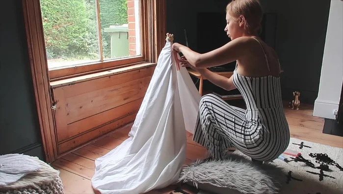 Glue fringing: Fold under the edge of the fabric for a neater look. Hot glue the pom-pom fringing, starting from the bottom and working upwards, to ensure even coverage.