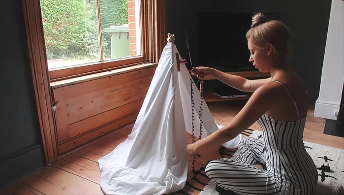 Glue fringing: Fold under the edge of the fabric for a neater look. Hot glue the pom-pom fringing, starting from the bottom and working upwards, to ensure even coverage.