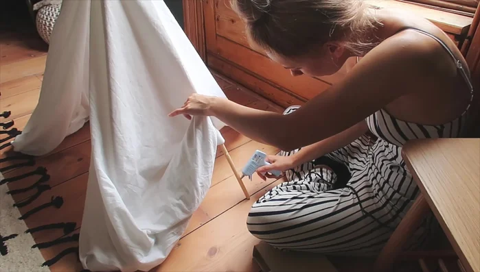 Secure fabric: Apply hot glue to the wooden dowels and press the fabric firmly to secure it. Repeat for all dowels.