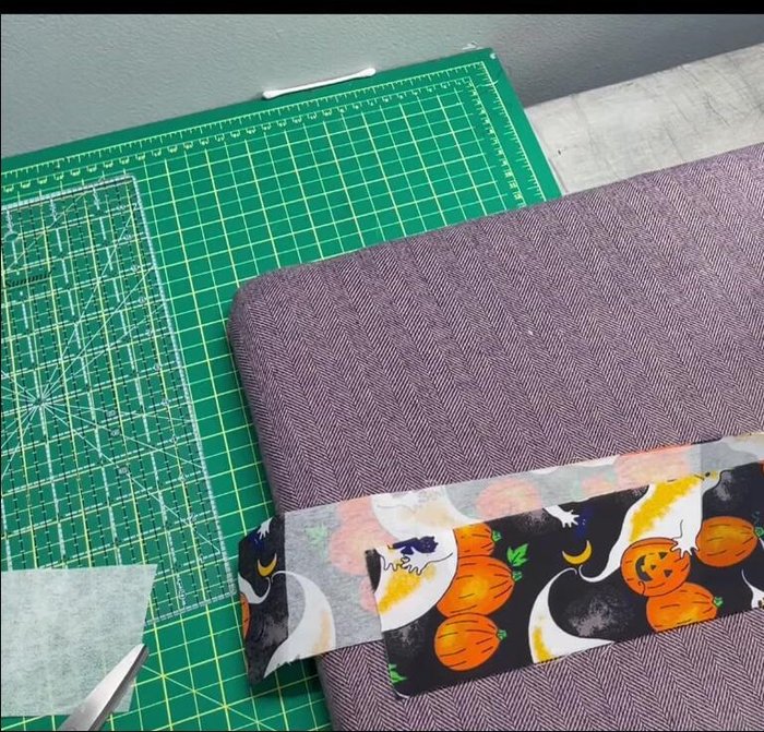 Press fabric: Fold one edge of the fabric (about 7/8 inch) and press. Repeat on the other side, using double-sided tape to secure the raw edges.