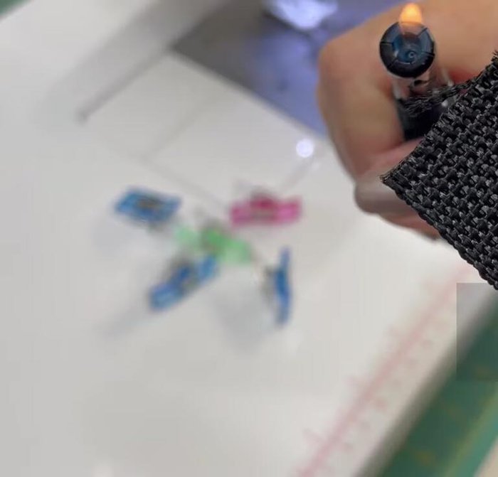 Attach webbing: Place the folded fabric onto the webbing, leaving a 1-inch overhang on each end. Clip to hold in place.