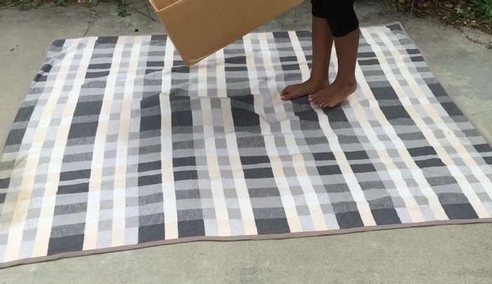 Place the outer blanket on a flat surface and center the box on top. Fold the edges of the blanket inside the box, smoothing out wrinkles to cover the entire box.